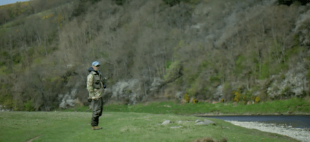 man fishing next to river