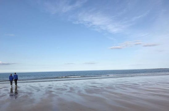 couple walking on sandy beach